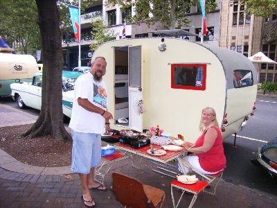 John and Lynelle ( cooking up a storm ) and their home made caravan.